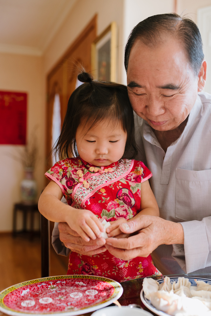 father Helping Granddaughter Making Dumplings